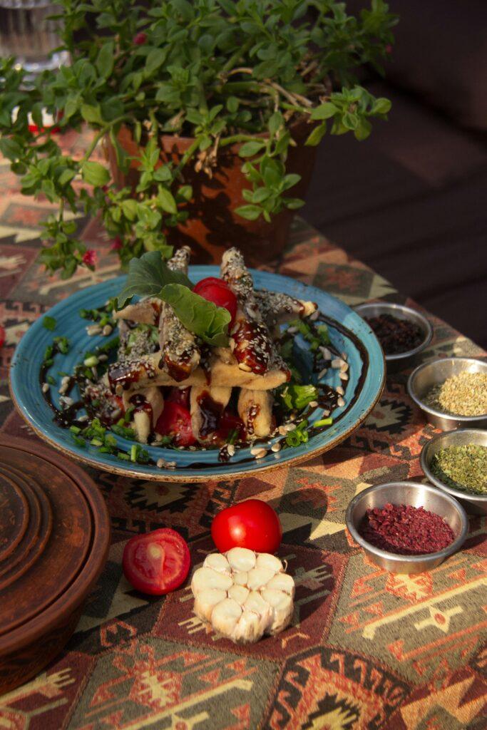 Colorful Mediterranean meal with fresh herbs on a patterned tablecloth, perfect for food enthusiasts.