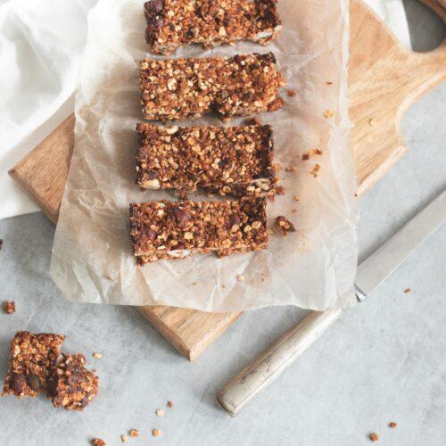 Delicious homemade granola bars on a wooden board, perfect for healthy snacking and meal preparation.