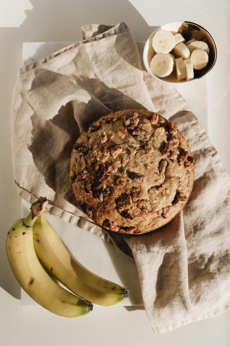 Fresh homemade spiced banana bread accompanied by ripe bananas and slices. Perfect lighting for food photography.